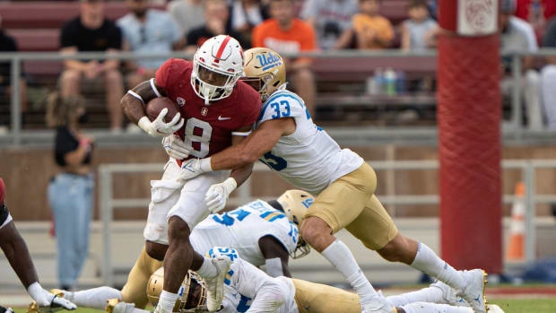 Sep 25, 2021; Stanford, California, USA; UCLA Bruins linebacker Bo Calvert (33) tackles Stanford Cardinal running back Nathaniel Peat (8) during the fourth quarter at Stanford Stadium. Mandatory Credit: Stan Szeto-USA TODAY Sports